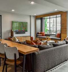 A living room with a sofa, chairs, and a television displaying a soccer game.