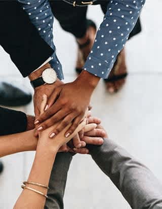 A group of people stacking their hands together.