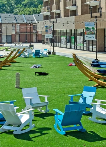 Outdoor seating and hammocks on grass at Trillium Apartments, Fairfax