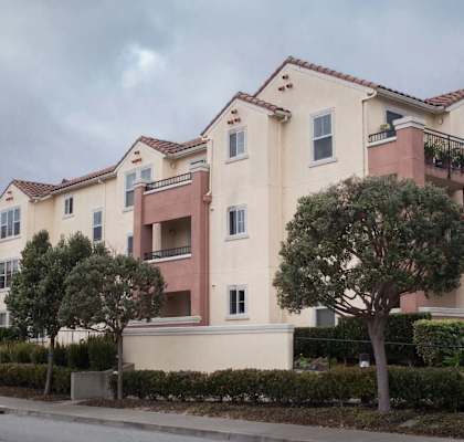 Apartment building with a cloudy sky in the background.