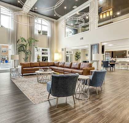 a living room with couches and chairs and a table at Vanguard Crossing, St. Louis, MO