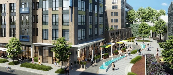 A modern apartment complex with a pool and a walkway.