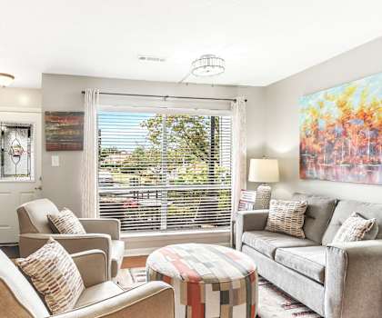 A living room with a grey couch, a chair, and a table.