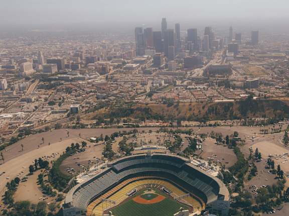 an aerial view of a baseball stadium with the city behind it