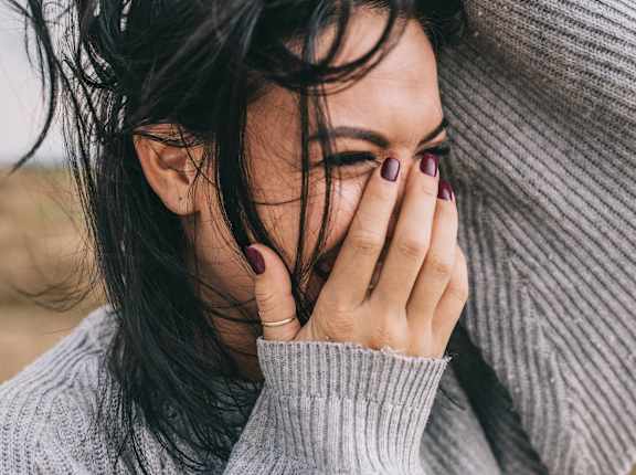 a woman covering her face with her hand