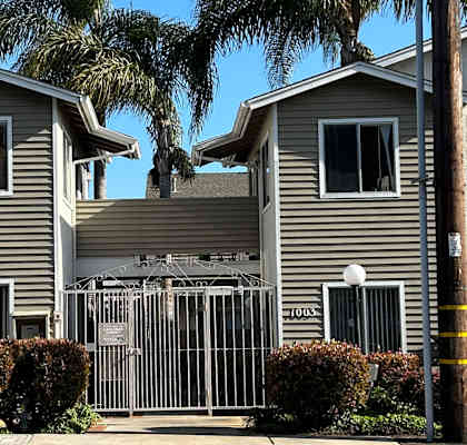 a gray house with a white fence in front of it