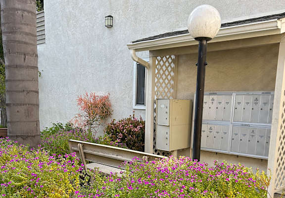 a house with mailboxes and a bench in front of it