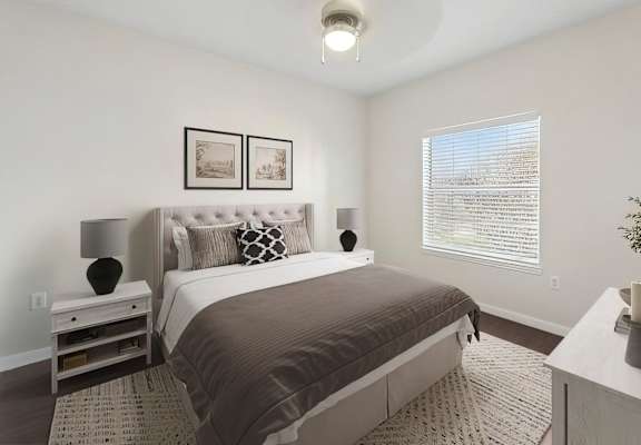 A bedroom with a large bed and a nightstand with a lamp.