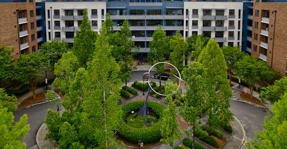 A large apartment complex with a courtyard and trees.