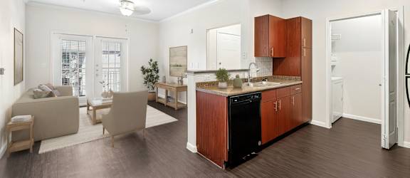 A modern kitchen with wooden cabinets and a black dishwasher.