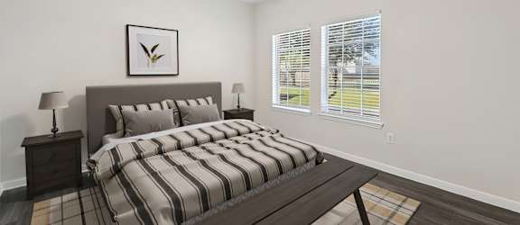 A bedroom with a bed, nightstand, and window.
