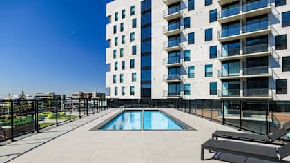 A modern building with a pool in the courtyard.