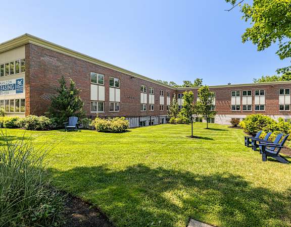 A sunny day at the school with a blue sign that says "FREE PARKING".