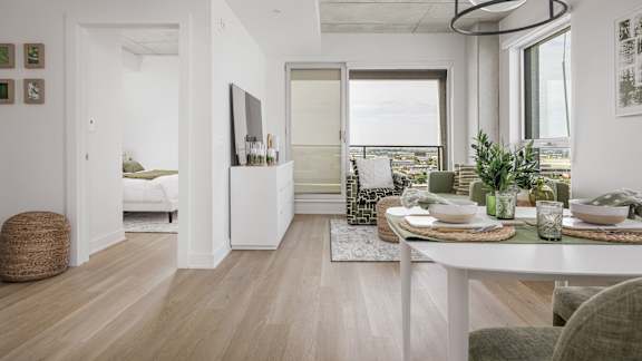A modern dining room with a white table set for two.