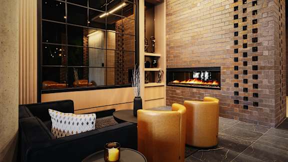 A modern living room with a fireplace and a black couch.