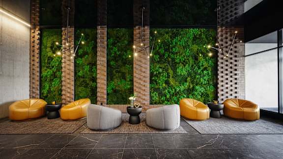 A room with a green wall and a black floor with several chairs and tables.