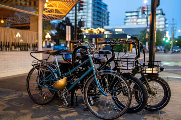Three bicycles parked next to each other on a sidewalk.