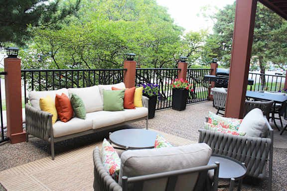 an outdoor patio with couches and a grill