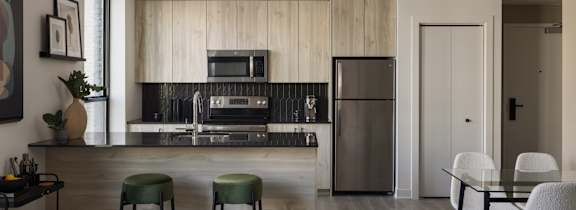 A modern kitchen with a bar area and a dining table.