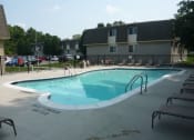 Thumbnail 14 of 17 - Outdoor swimming pool next to building with patio chairs