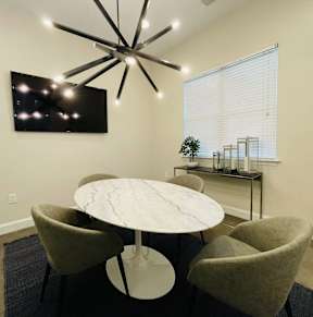 A modern dining room with a round table and chairs.