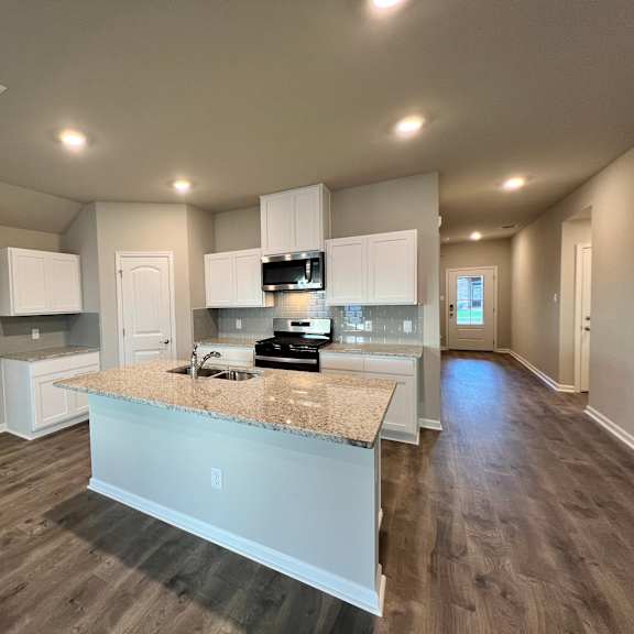 A kitchen with a granite countertop and white cabinets.