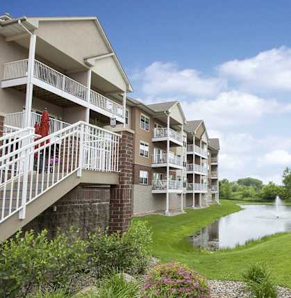 a building overlooking a pond with a fountain