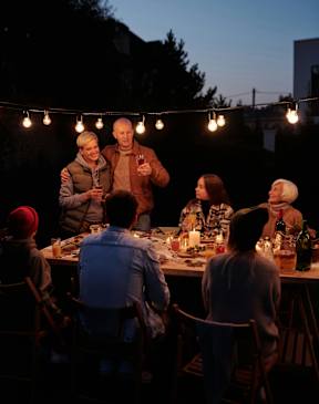 A group of people are gathered around a table for a dinner party.