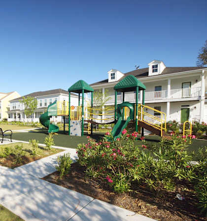 a playground in a park in front of apartments