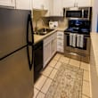 A kitchen with a black refrigerator and stove.