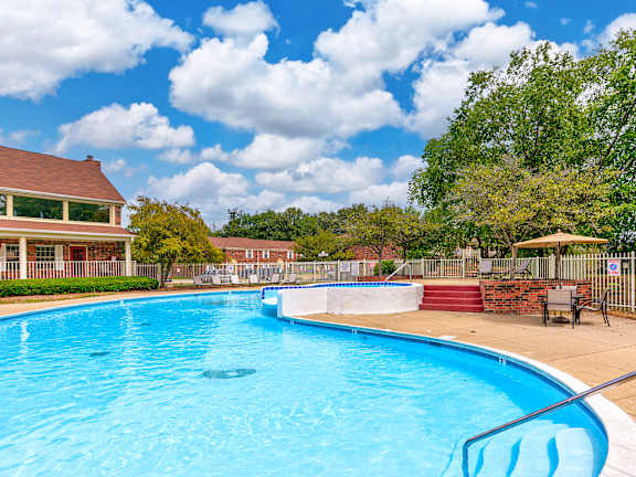 A large swimming pool with a blue tinted water and a white fence surrounding it.at Spinnaker Court, Indiana, 46214