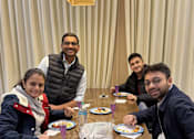 Thumbnail 15 of 17 - Four people sitting at a table with plates of food in front of them.