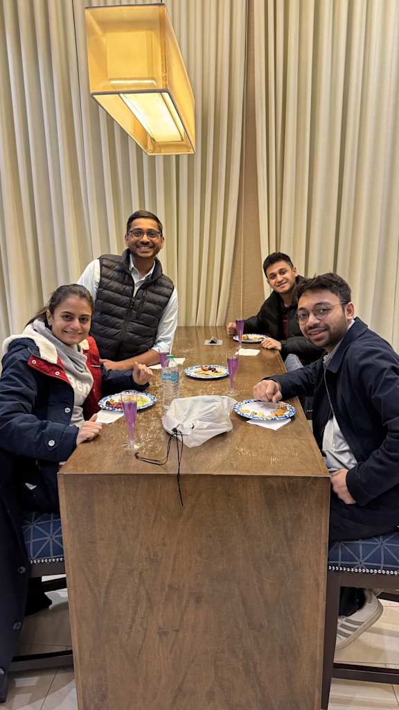 Four people sitting at a table with plates of food in front of them.
