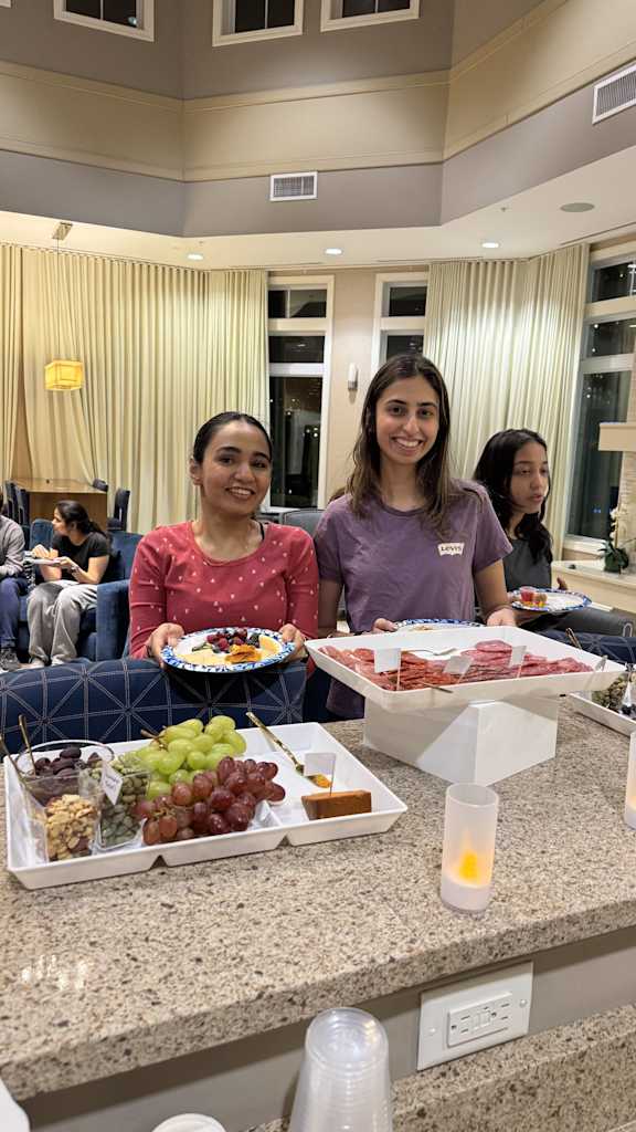 Three women are sitting at a table with food in front of them.