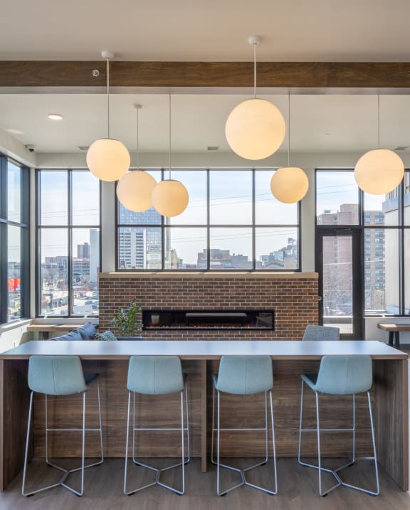 a kitchen with a long island with blue chairs in front of it and a fireplace in the