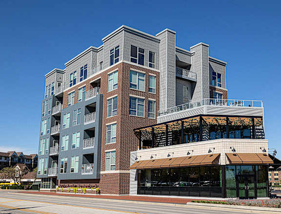 A modern multi-story building with a mix of brick and panel facades.