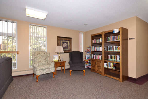 a living room with two chairs and a bookcase