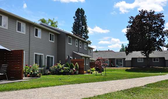 a row of houses with a sidewalk in the grass