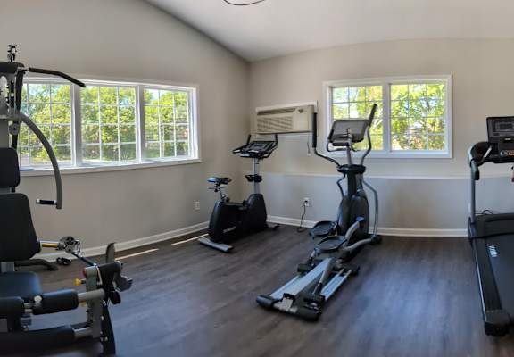gym with exercise equipment and windows in a room with wood floors