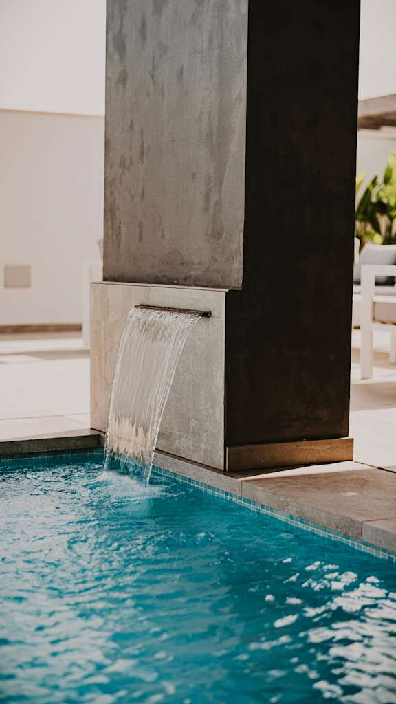 A pool with a waterfall feature in the middle.