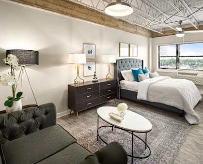a bedroom with a bed and a desk in a room