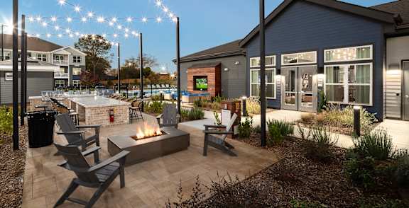 A patio area with a fire pit and chairs.