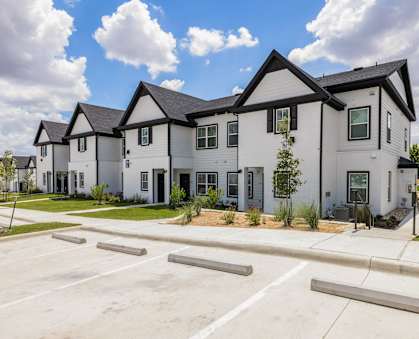 an empty parking lot in front of some houses