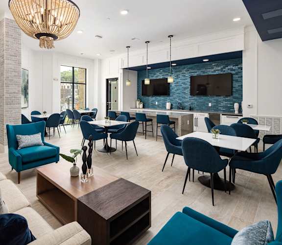 A modern living room with blue chairs and a wooden coffee table.