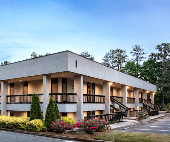 A modern building with a flat roof and a balcony on the second floor.