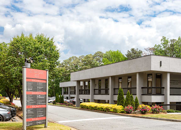 A modern building with a parking lot in front.