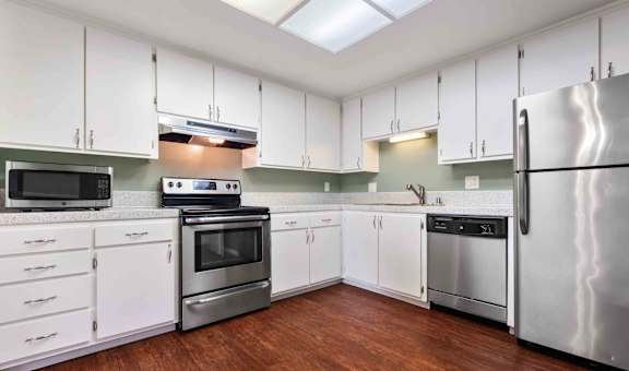 a kitchen with white cabinets and stainless steel appliances