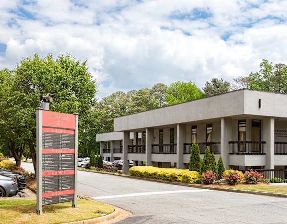 A modern building with a parking lot in front.