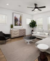 a living room with a couch and a chair and a ceiling fan