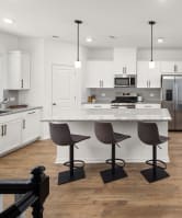 an open kitchen and dining area with a round table and chairs